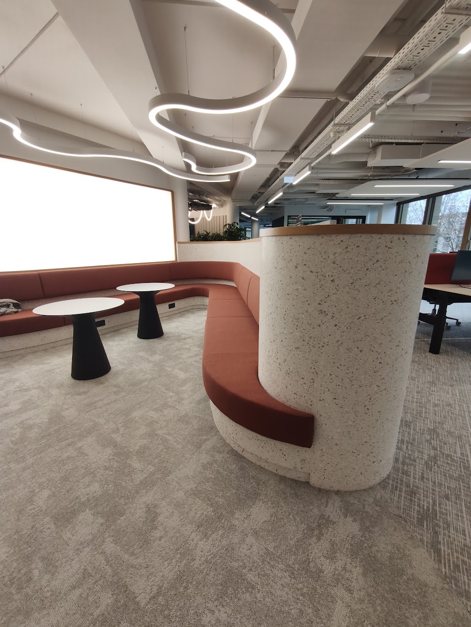 Banquette et comptoir en terrazzo préfabriqué dans un espace de bureaux